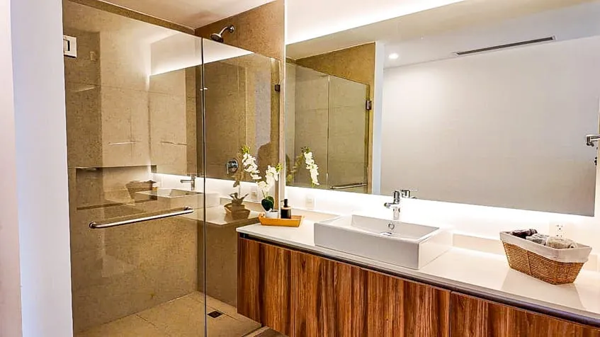un baño con un lavamanos y una ducha elegante en the leaf condos playacar