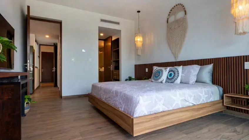 una cama amplia y 1 baño al fondo en the leaf condos playacar
