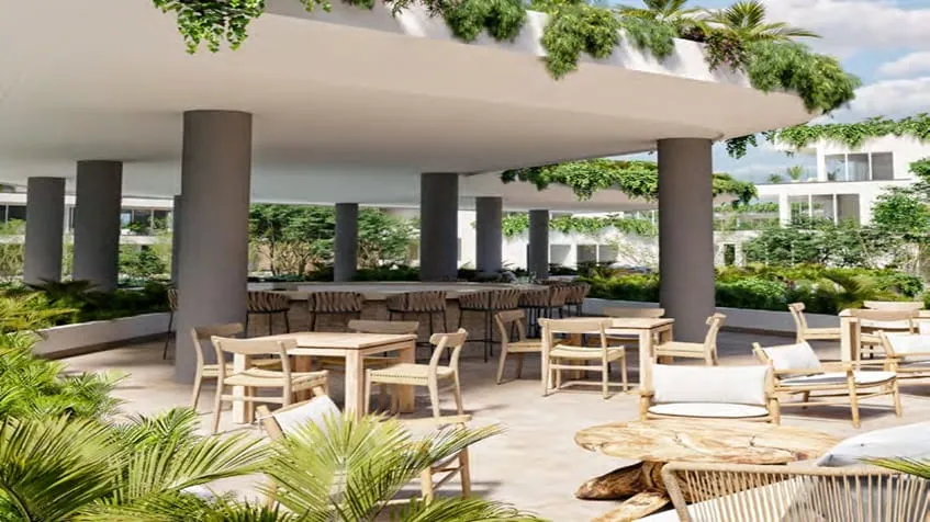 un area social con mesas y sillas en the leaf condos playacar