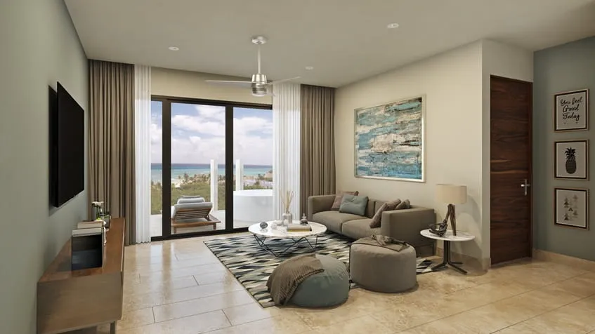 una sala con una tv y un sofa con una terraza con vista al mar en serenada playa del carmen