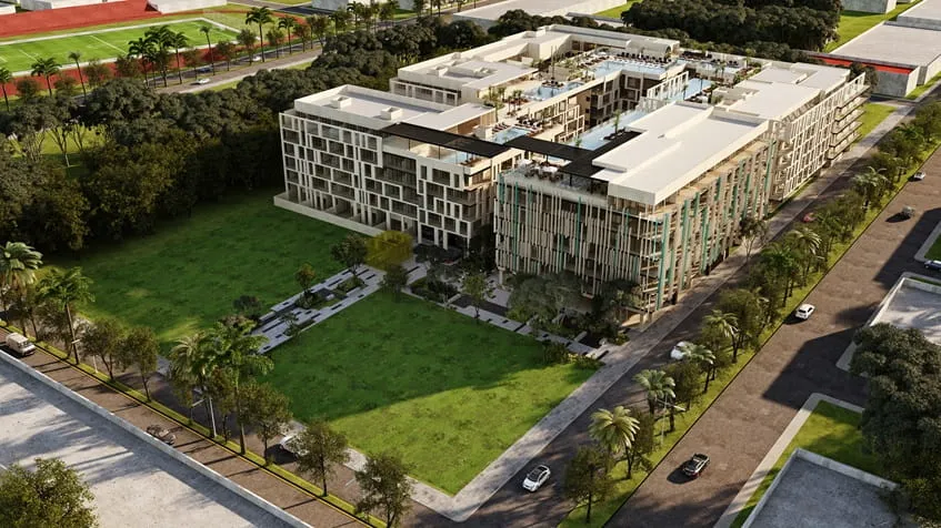 una vista aerea de un edificio de departamentos y areas verdes alrededor en serenada playa del carmen
